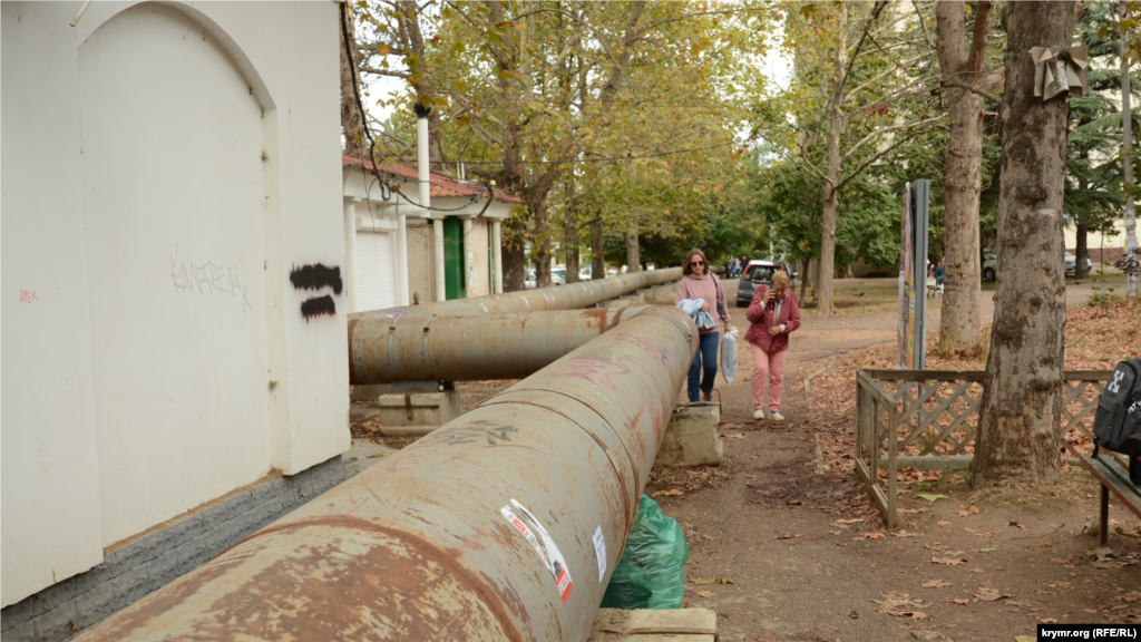 Труба тимчасового водопроводу огинає будівлю аптеки на проспекті Острякова