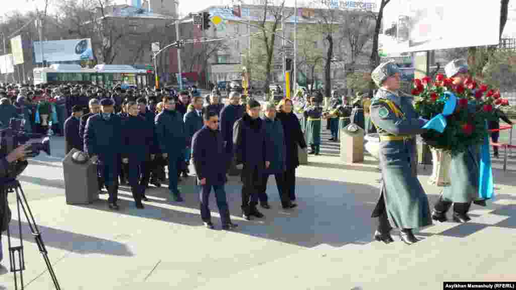 Алматы қаласының әкімі Бауыржан Байбек (ортада) бастаған шенеуніктер Желтоқсан оқиғасы құрбандары құрметіне тұрғызылған &laquo;Тәуелсіздік таңы&raquo; ескерткішіне гүл қоюға келді. Алматы, 17 желтоқсан 2015 жыл.