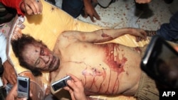 Libya -- Libyans take pictures with their mobile phones of the body of Muammar Qaddafi in Misrata, 20Oct2011 !!GRAPHIC CONTENT