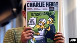 На обложке Charlie Hebdo карикатура названа "Неприкасаемые 2" (изображен имам на инвалидной коляске, которую везет ортодоксальный иудей), 19 сентября 2012